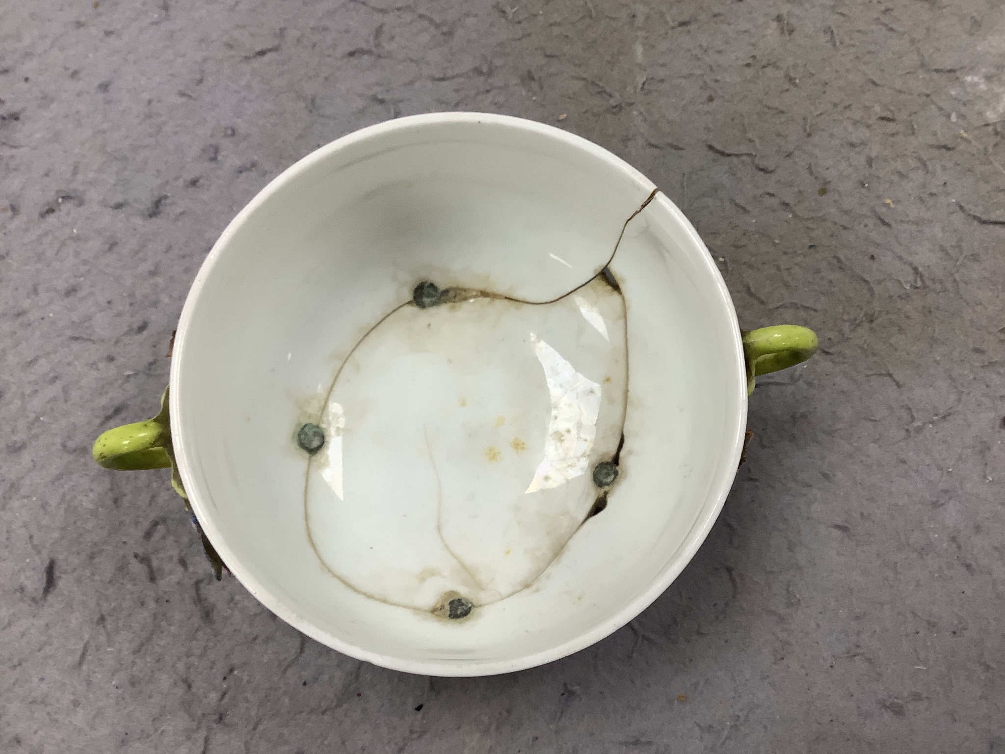 A Chelsea ecuelle base with twig handles painted with Meissen style flowers, red anchor mark, a Derby mug painted with flowers and scattered sprigs, a Coalport mug in the Chinese export style, a Caughley leaf shaped pick